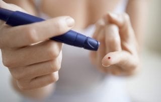 Лечение сахарного диабета в Германии. Женщина делает анализ крови на сахар. Фото